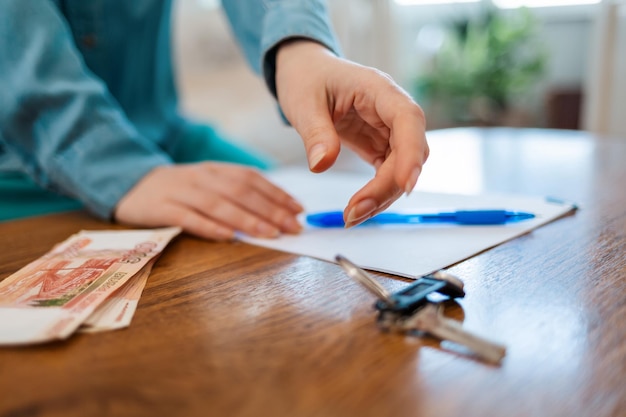 A close-up of hands signing a loan consolidation document with a pen, symbolizing the act of taking control of one's student loan debt.