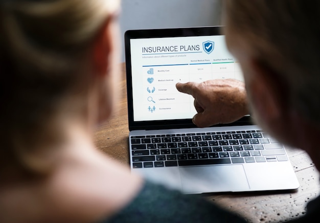 A person using a laptop with a car insurance policy document displayed on the screen. The scene emphasizes the ease and importance of online insurance reviews.