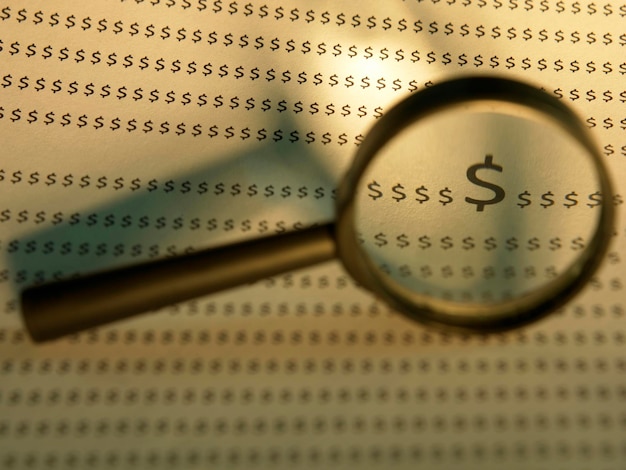 A magnifying glass focusing on the fine print of an investment prospectus, highlighting the importance of reading and understanding all fees and terms.