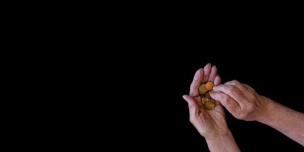 A close-up of a person's hand holding a coin, with upward arrows symbolizing rising inflation in the background. The lighting is dramatic, accentuating the stress of inflation on personal savings.
