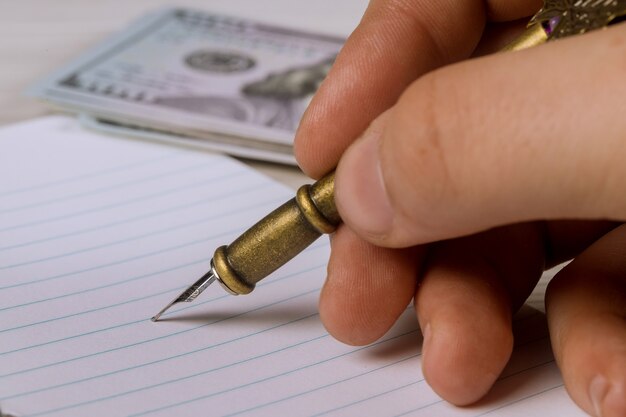 A close-up of hands completing a financial planning document with a pen, highlighting sections on asset allocation and retirement savings.