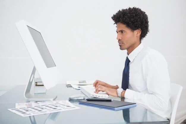 An accountant working on a computer with tax forms and financial documents displayed on the screen, emphasizing the importance of professional assistance in claiming the General Business Credit.