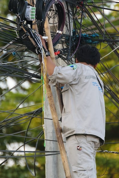 Workers installing fiber optic cables underground, symbolizing the expansion of broadband internet access in rural areas. The image should convey connectivity, technology, and progress.