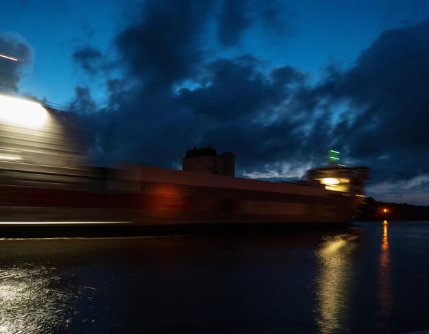 A container ship stuck in a harbor due to delays. Show the containers backed up for miles.