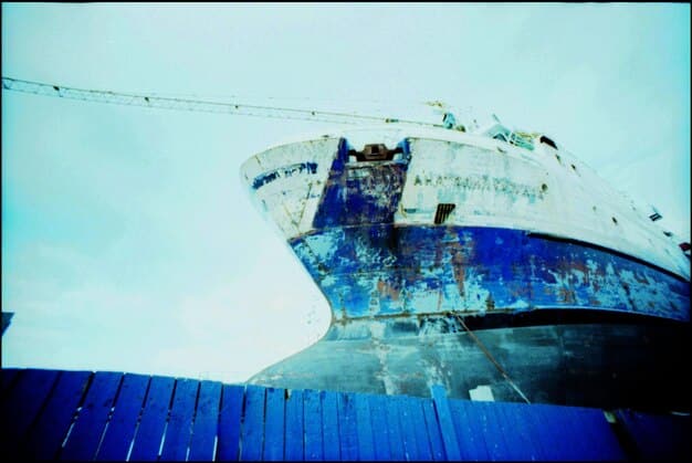 A photograph of cargo ships stuck in a harbor, unable to unload goods. Overlaid on the image are statistics showing the increase in shipping costs and delays, and the drop in production for the US automotive industry.