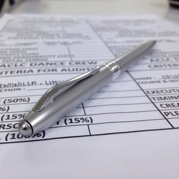A close-up shot of a US tax form (Form 1040) with the Earned Income Tax Credit section clearly highlighted. A pen is resting on the form, and a calculator is visible in the background.